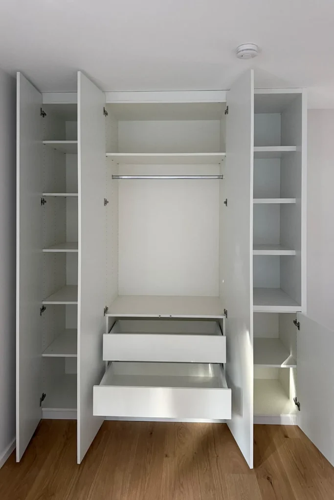 Offenes Küchen-Hochschrank-Element mit Einlegeböden und zwei weißen Schubkästen, seitliche Fachbereiche.
